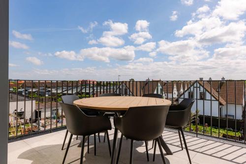 a table and chairs on a balcony with a view at Huswell - New Beach Apartment in De Haan in De Haan