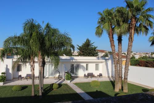 a house with palm trees in front of it at Dani's residence in Supersano