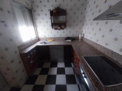 a kitchen with a sink and a checkered floor at Habitación Mercadona B in Cantillana
