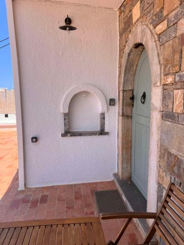 a door of a building with a bench next to it at Gioma Garden Villas in Istron