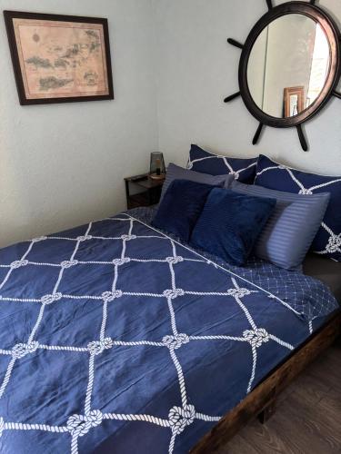 a bed with a blue comforter and a mirror at Pirate's Cove in Sukošan