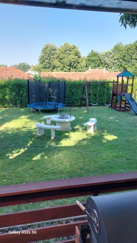 a park with a playground with two swings at Anno Apartman in Balatonföldvár