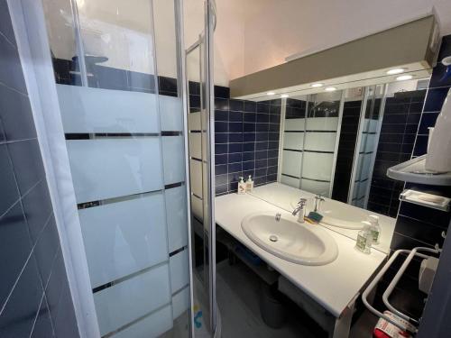 une salle de bain avec un lavabo et un miroir dans l'établissement T2 rénové avec cabine, piscine, animaux admis, parking à 500m de la plage - FR-1-106-49, à Saint-Cyprien