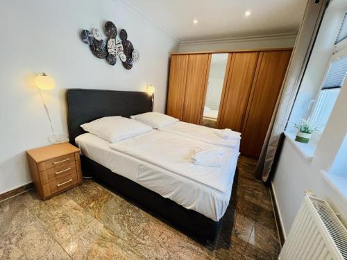 a bedroom with a bed with a night stand and a window at Strandsicht, direkt am Strand in Warnemünde