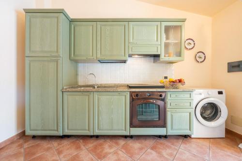 a kitchen with green cabinets and a washing machine at AffittaSardegna - Casa dei Pescatori in Santa Lucia