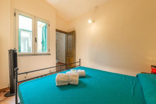 a bedroom with a bed with two towels on it at AffittaSardegna - Casa dei Pescatori in Santa Lucia