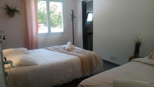 a hotel room with two beds and a window at Chti Moutchico in Lacanau