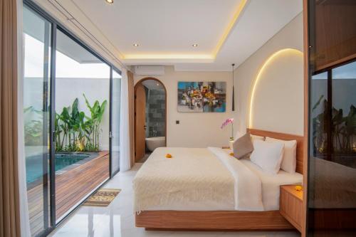a bedroom with a large bed and a balcony at Nidya Villa Canggu in Canggu