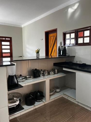a kitchen with shelves and pots and pans at É De Casa Unidade 03 in Juazeiro do Norte