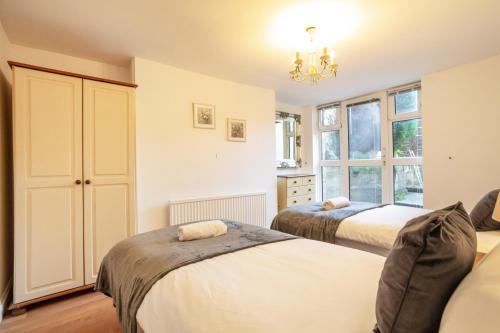 a bedroom with two beds and a chandelier at Prospect Place Long Stay Free Parking and Wi-FI in Swindon