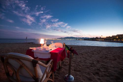 a table on the beach with a candle on it at Shams Prestige Abu Soma (Adults Only) in Hurghada
