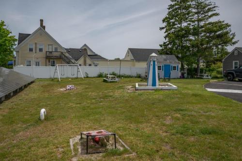 a yard with a swing set and an umbrella at Jonathan Edwards Motel in Dennis Port