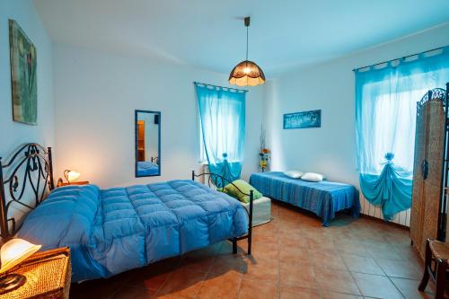 a bedroom with two beds and blue walls at B&B Centro Ippico Andrea in Porto Recanati