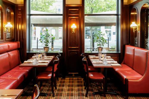a restaurant with two tables and chairs and windows at Best Western Plus Hotel Eyde in Herning