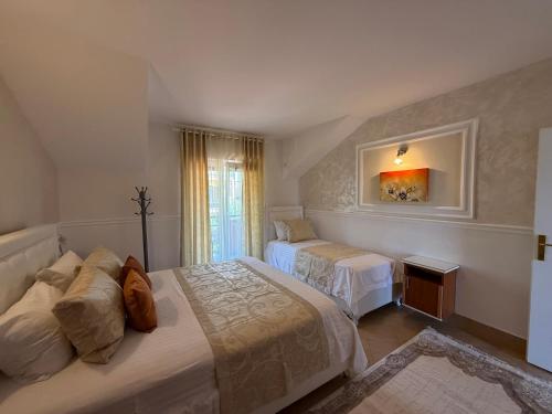 a hotel room with two beds and a window at Grand Apartments Scepanovic in Tivat