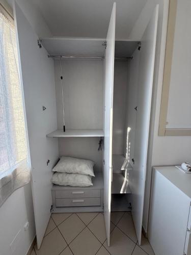 a small white room with a bed in it at La Casetta Del Borgo in Ravenna