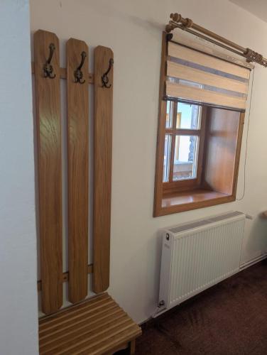 a room with a wooden bench next to a window at Vila Bârsana in Bîrsana