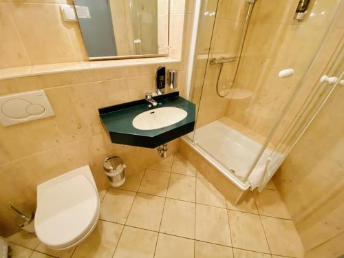 a bathroom with a toilet and a sink and a shower at Doppelzimmer Buffet, direkt am Alten Strom in Warnemünde