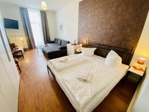 une chambre avec un lit blanc et un canapé dans l'établissement Doppelzimmer Cocktail, direkt am Alten Strom, à Warnemünde