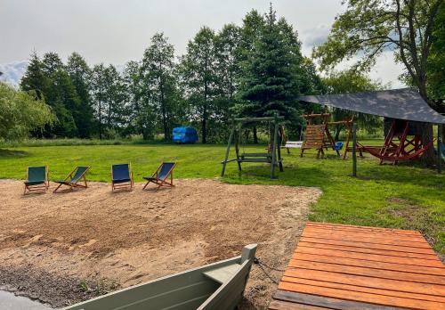 a playground with chairs and a swing set at Agroturystyka Katarzyna Tarasiewicz in Stary Folwark