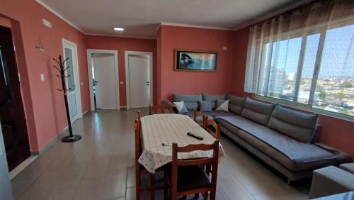 a living room with a couch and a table at Maksimilian Apartament in Durrës