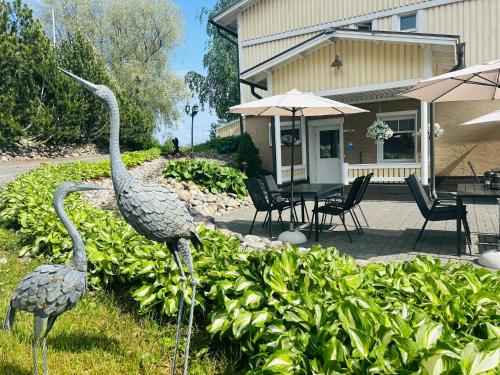 two statues of birds in the grass near a house at Mansikkaniemen Lomakeskus in Rantasalmi