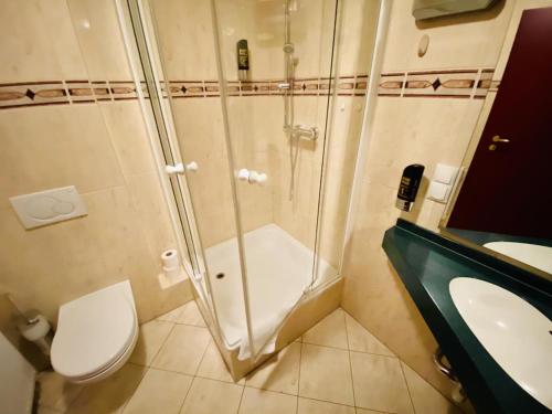 a bathroom with a shower and a toilet and a sink at Doppelzimmer Lounge, direkt am Alten Strom in Warnemünde
