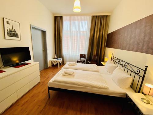 a bedroom with a large bed and a flat screen tv at Doppelzimmer Menue, direkt am Alten Strom in Warnemünde
