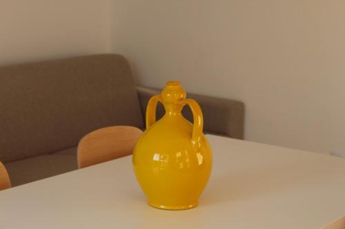 a yellow vase sitting on top of a table at Dani's residence in Supersano