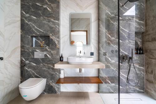 a bathroom with a sink and a toilet and a mirror at Jago Gili Air in Gili Islands