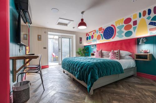 a bedroom with a bed with a colorful wall at Ffolkes Arms Hotel in Hillington