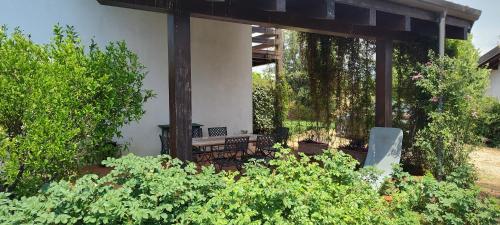 a screened in porch with a bench in a garden at Casa Cardea in Aprilia