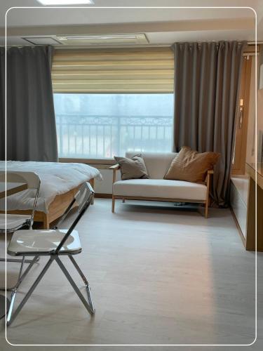 a room with a bed and a couch and a window at Gangnam Cozy home 7 min to subway in Seoul