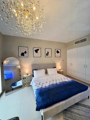 a bedroom with a blue bed and a chandelier at Luxurious Studio Pacific Al Marjan Island - beachfront property in Ras al Khaimah