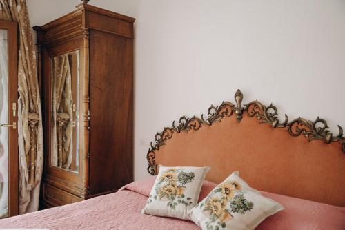 a bed with a wooden headboard and two pillows on it at Agriturismo I Millepini in Case Malva