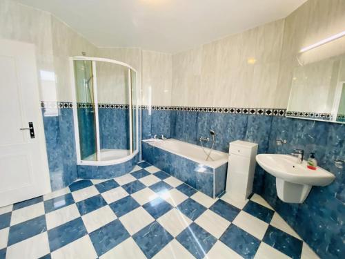 a blue and white bathroom with a tub and sink at Marthes Seeblick in Warnemünde