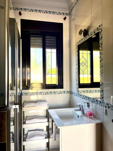 a bathroom with a sink and a mirror at Apartamentos Los Mellizos in Conil de la Frontera