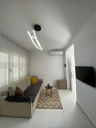 a living room with a couch and a flat screen tv at Villa Oliver in Hamallë