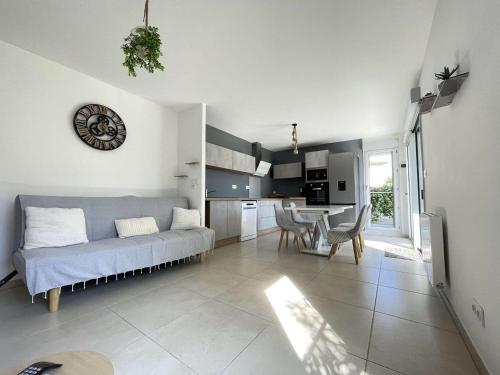 un salon avec un canapé et une cuisine avec une table dans l'établissement Appartement T3 neuf avec terrasse et parking proche plage - FR-1-308-210, au Lavandou