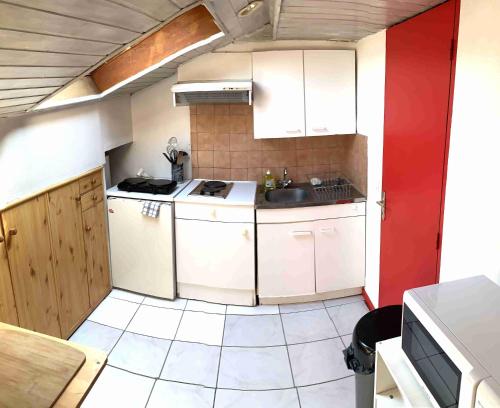 une petite cuisine avec des armoires blanches et un évier dans l'établissement Studio ITALY, à Chambéry