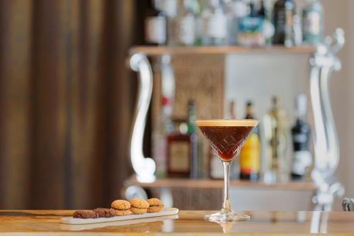 a drink in a glass sitting on a table with cookies at Manzi Hotel & Spa in Ischia
