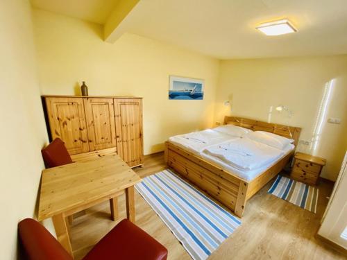 a bedroom with a large bed and a wooden table at Sonnendeck, direkt am Leuchtturm in Warnemünde