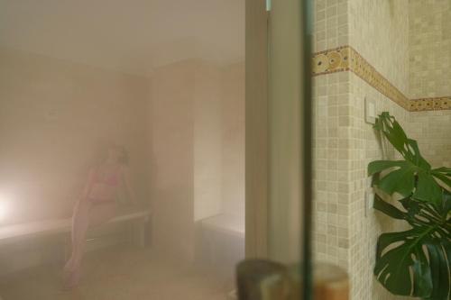 a woman sitting on a bench in a room at Manzi Hotel & Spa in Ischia