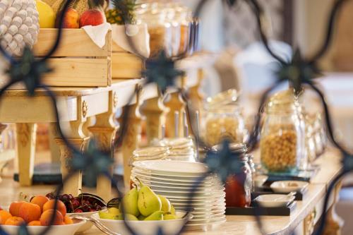 a table with bowls of fruits and plates on it at Manzi Hotel & Spa in Ischia