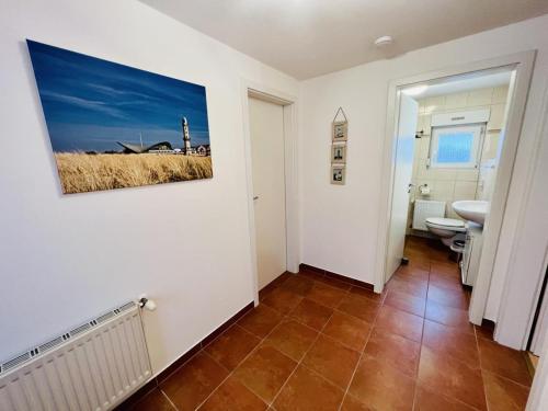 a bathroom with a painting on the wall at Ferienhaus Streuwiese in Warnemünde