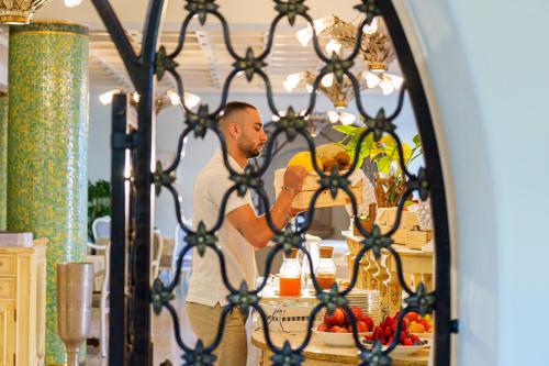 a man holding a fruit in front of a mirror at Manzi Hotel & Spa in Ischia