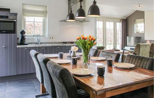 a kitchen and dining room with a wooden table and chairs at Buitengoed Het Lageveld - 108 in Hoge-Hexel