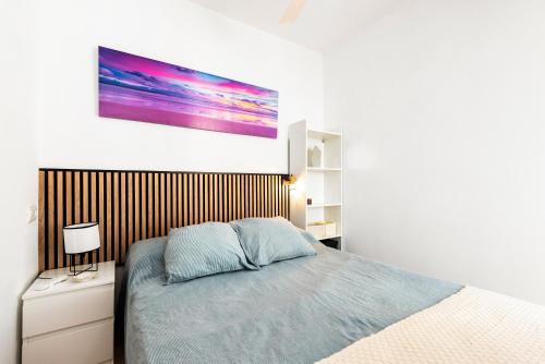 sypialnia z łóżkiem i obrazem na ścianie w obiekcie Apartamento Lucía w mieście Torre del Mar