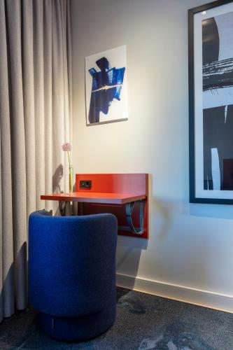 a room with a blue chair and a table at Home Hotel Carlscrona in Karlskrona