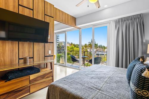 a bedroom with a bed and a tv and a balcony at Viva la vida in Bucerías